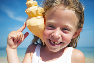 a child playing with a sea shell